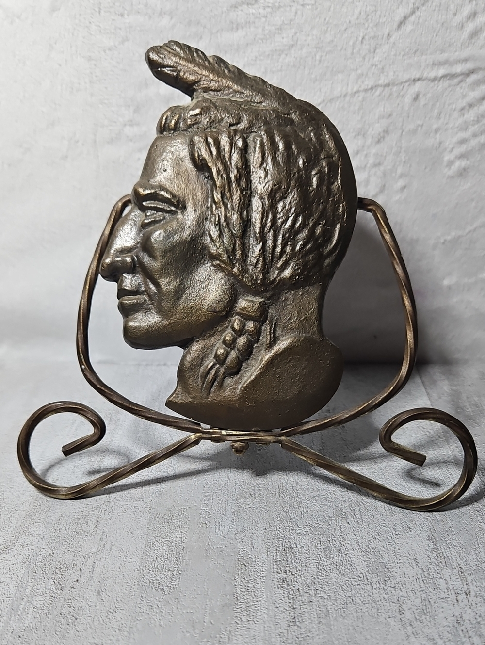 Brass Native American chief profile bust mounted on a decorative Stand